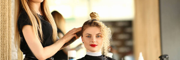 Женщина парикмахер и клиент с кудрявой прической
