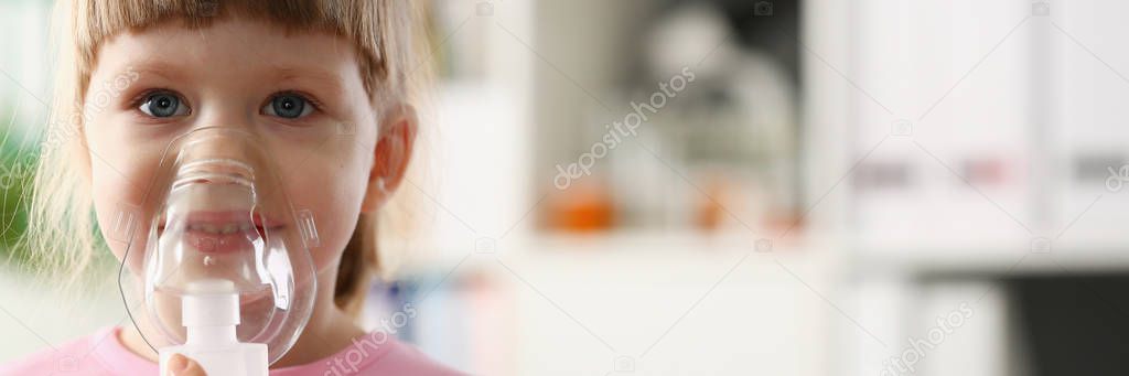 Little girl breathing with inhaler at doctor office