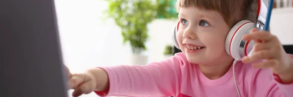 Niña usando auriculares use computadora móvil — Foto de Stock