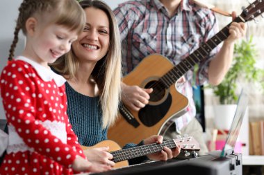Mutlu aile arka planda müzik enstrümanları çalıyor