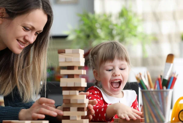 Ung mamma med liten dotter spela spel i trä block — Stockfoto