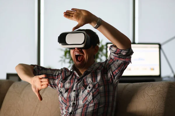 Mann sitzt zu Hause auf der Couch und nutzt Virtual Reality — Stockfoto