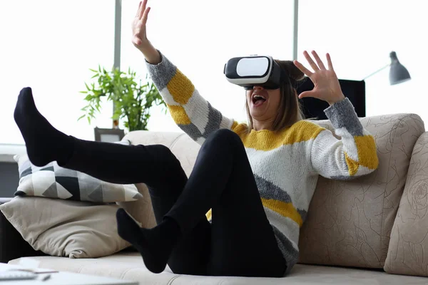 Mulher senta-se em casa no sofá usa realidade virtual — Fotografia de Stock