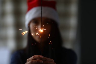 Kadın maytapları elinde tutuyor.