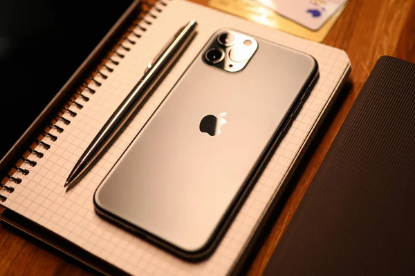 Apple iphone pro with silver pen on notebook — 스톡 사진