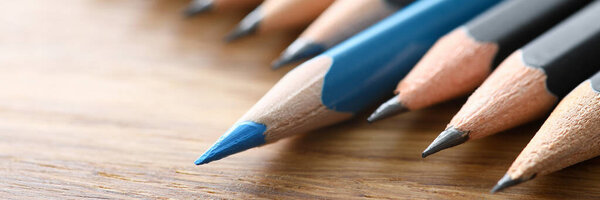 Blue pencil spy between black pencils