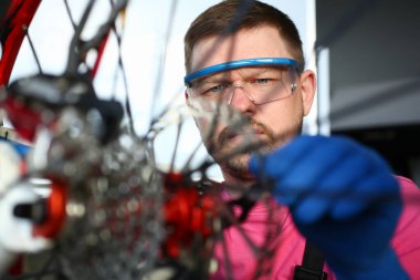 Koruyucu eldivenli ve gözlüklü adam.