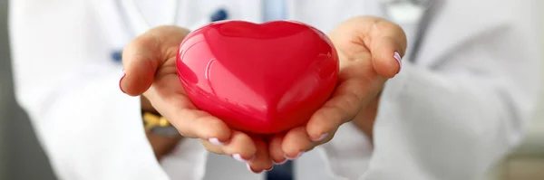 Female cardiolog holding in arms red toy heart — Stock Photo, Image