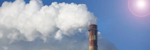 Vit rök kommer från rören mot blå himmel — Stockfoto