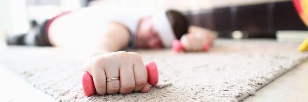 Уставший спортсмен лежит на полу с гантелями — стоковое фото