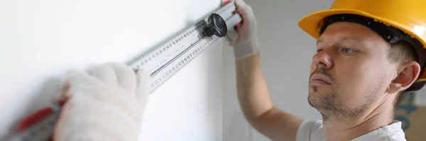 Maschio lavoratore in casco giallo tenere edificio — Foto Stock