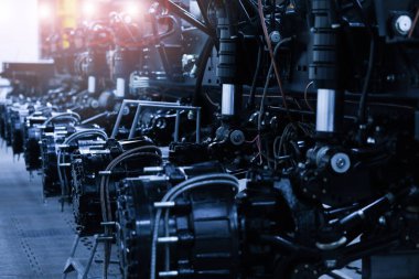 Bir otomobil metalurji fabrikasının konveyöründe ağır traktör.