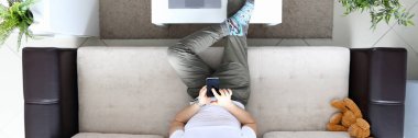 Kanepeye otur ve modern akıllı telefonu elinde tut.