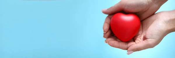 Kobieta ręka trzymać czerwony zabawka serce w ręka zbliżenie — Zdjęcie stockowe