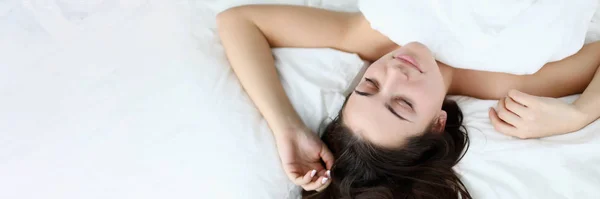 Jeune femme de beauté caucasienne dormant sur lit blanc — Photo