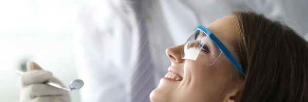 Mannelijke tandarts werken met gelukkig en glimlachende vrouwelijke bezoeker — Stockfoto