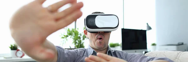 Mann sitzt zu Hause auf der Couch und nutzt Virtual Reality — Stockfoto