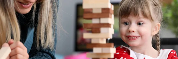 Junge Mutter mit kleiner Tochter spielen Spiel im Holzblock — Stockfoto