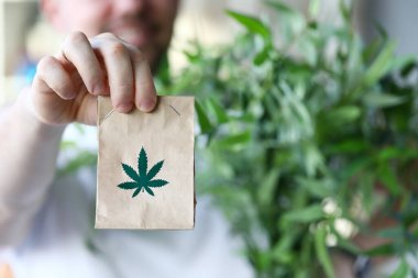 Marihuana sembollü erkek el çantası yakın plan.