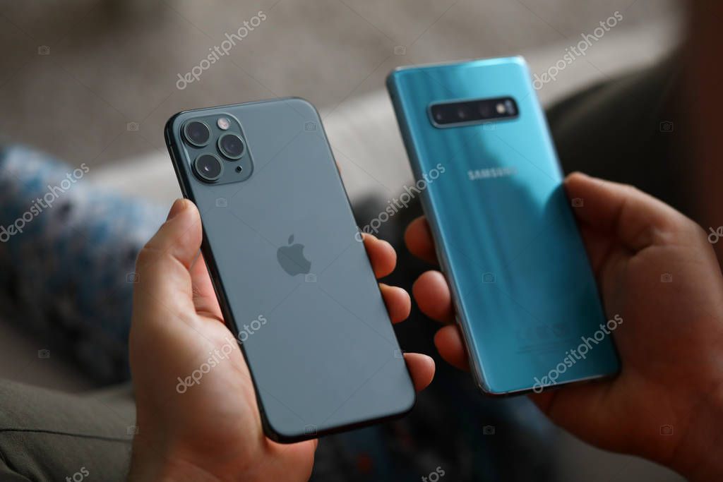Minsk, Belarus - 11 December 2019 : Male hand hold Apple iphone pro and samsung galaxy s 10. Illustrative editorial