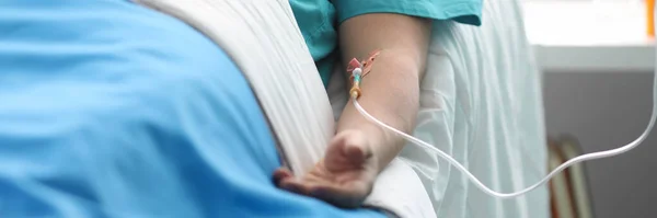 Рука молодого чоловіка з крапельницею в палаті медичної лікарні — стокове фото