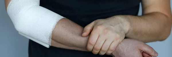 Чоловіча рука з щільною еластичною пов'язкою на лікті крупним планом — стокове фото