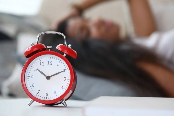 Tired woman sleeping couch, set wake up time alarm — Stock Photo, Image