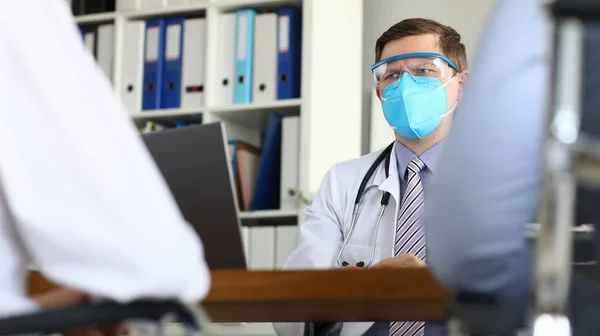 Male doctor suspiciously looks at patient suspects severe stage of virus — Stockfoto