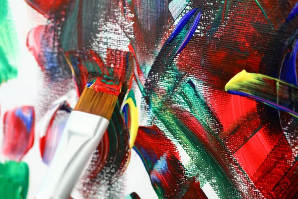 Brush with acrylic paint on background of art canvas — Zdjęcie stockowe