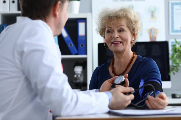 Male doctor measures pressure an elderly woman — Stock Photo, Image