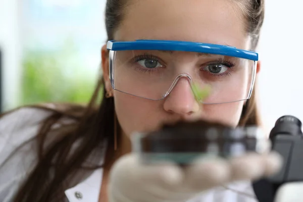 Girl is holding test tube with earth palm her hand — Stockfoto