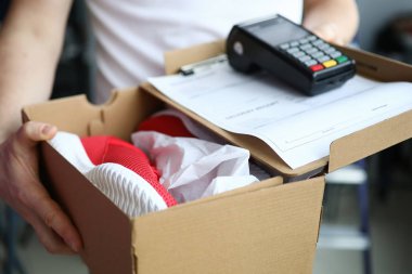 Man holds box with sneakers terminal for payment