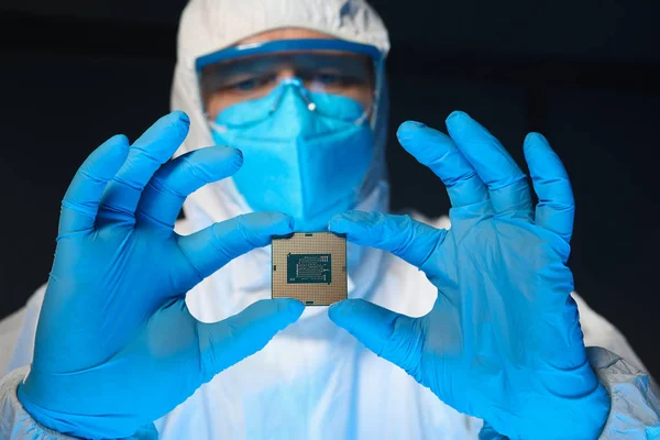Homem em uniforme especial mostra microprocessador chip — Fotografia de Stock
