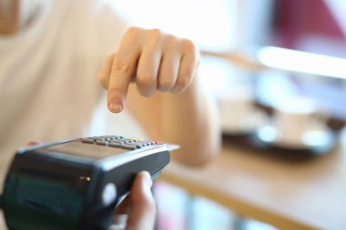 Man dials a PIN code at terminal, payment by card