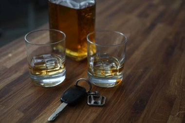 Car key lies on table next to bottle alcohol