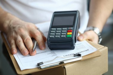 Adam paket teslim belgesini ve uçbirimini elinde tutuyor