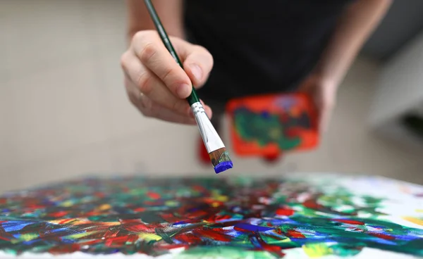 Talented male holding paintbrush — Stockfoto