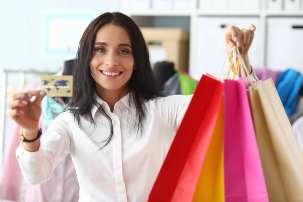 Mujer con estilo muestra tarjeta de crédito y paquetes — Foto de Stock