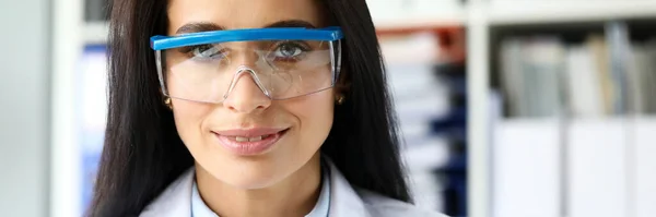 Mooie vrouwelijke assistent zittend op werktafel kijken in camera — Stockfoto