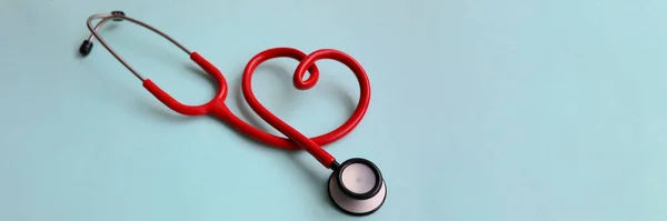 Красный стетоскоп с сердцем на синем современном фоне — стоковое фото