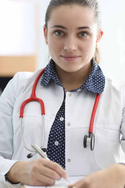 Kobieta lekarz ze stetoskopem wypełnia dokument — Zdjęcie stockowe