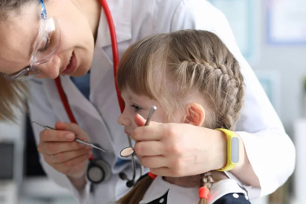 Pediatrische tandarts onderzoekt tanden klein meisje — Stockfoto