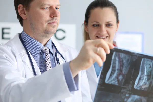 Les médecins masculins et féminins regardent attentivement une radiographie — Photo