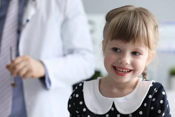 Здоровая маленькая девочка сидит в кабинете врача — стоковое фото