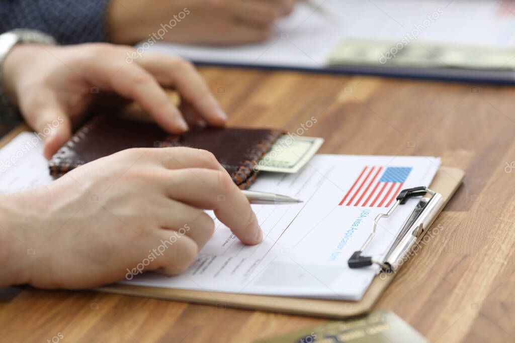 Male hands in suit lie on application for usa visa