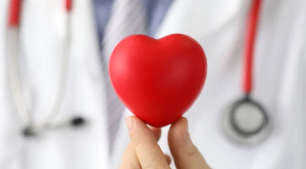 Доктор держит сердце с черной точкой, кардиостимулятор — стоковое фото