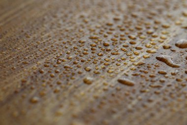 Damlalar koyu ahşap yüzeye püskürtülür.