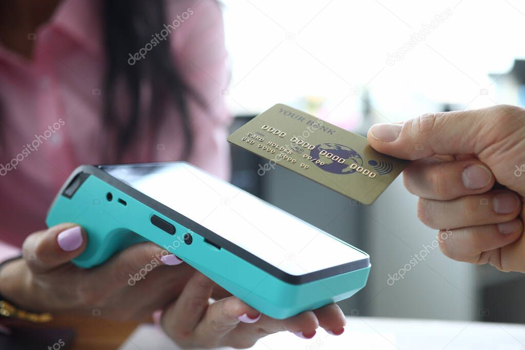 Man holds contactless credit card to terminal