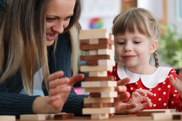 Mamma och dotter bygger träklossar bord — Stockfoto