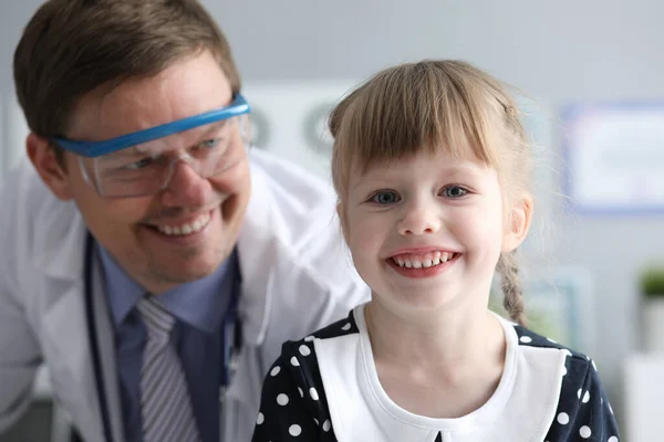 Улыбающийся врач выглядит здоровым счастливым ребенком — стоковое фото